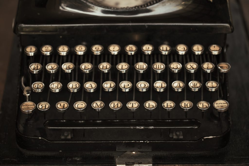 Old black typewriter with paper worth on the table